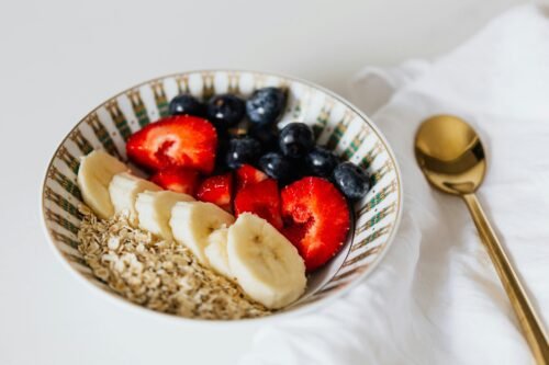 A vibrant bowl of oats with sliced bananas, strawberries, and blueberries, ideal for a healthy breakfast.